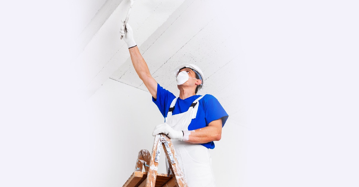 A specialist wearing PPE applies antibacterial ceiling paint at a London's office
