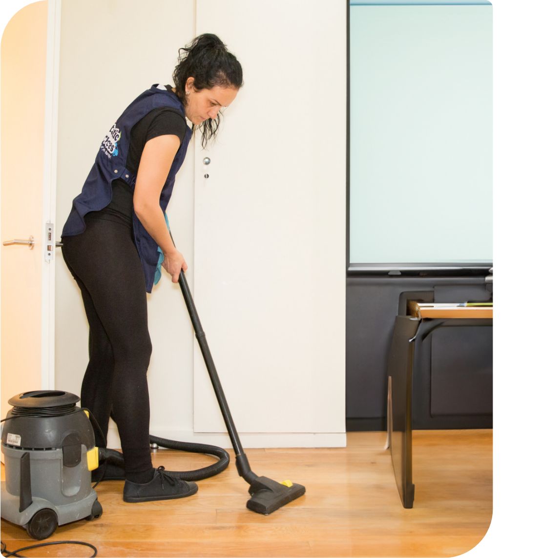 Professional cleaner vacuuming office floor