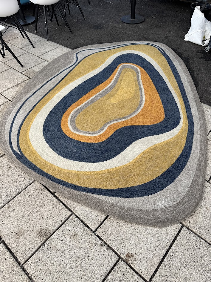 A freshly cleaned multicolored rug on tiled flooring, displaying bright and vibrant colors after professional rug cleaning service.