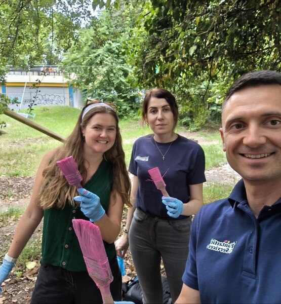 fantastic-services-corporate-team-playground-refurbishment Fantastic Services team members and Kids representative holding paintbrushes during the Lady Allen Adventure Playground refurbishment.