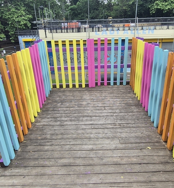 lady-allen-playground-colourful-platform-railings Freshly painted colourful railings around the raised wooden play platform at Lady Allen Adventure Playground.