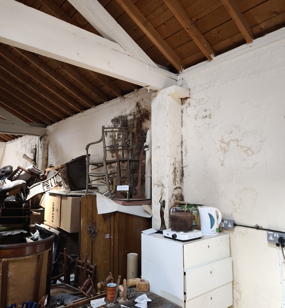 mould-damaged-wall Workshop interior with extensive mould growth and damp damage on the walls